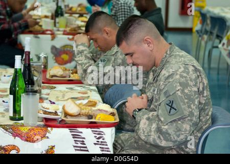 Les soldats déployés au Kosovo dans le cadre de la KFOR 16 prendre une minute avant de savourer leur repas de Thanksgiving au Camp Bondsteel's dining Banque D'Images