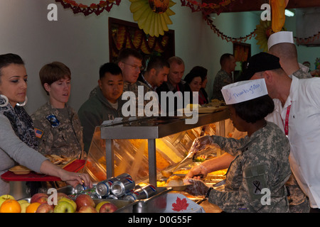 Les chefs de service, les officiers et sergents d'abord, servir un repas de Thanksgiving aux soldats et civils à Camp Bondsteel, au Kosovo. La salle d'eau, fournies une corne de l'alimentation à partir de la côte de bœuf et la Turquie, à la tarte aux pacanes. Les gestionnaires d'installations supplémentaires ont travaillé de pair Banque D'Images