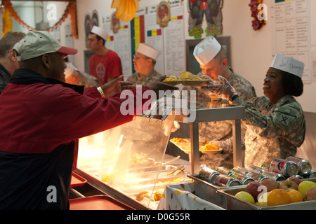 Les chefs de service, les officiers et sergents d'abord, servir un repas de Thanksgiving aux soldats et civils à Camp Bondsteel, au Kosovo. La salle d'eau, fournies une corne de l'alimentation à partir de la côte de bœuf et la Turquie, à la tarte aux pacanes. Les gestionnaires d'installations supplémentaires ont travaillé de pair Banque D'Images