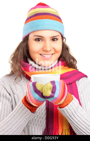 Une femme souriante portant un chapeau et un foulard et tenant une tasse de thé isolé sur fond blanc Banque D'Images