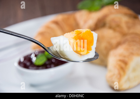 Avec une cuillère d'oeufs de pièce et un croissant dans l'arrière-plan Banque D'Images