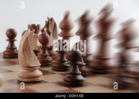 Chevalier blanc face à des pièces d'échecs Banque D'Images