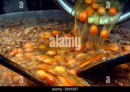 Oeufs cassés, verser dans un grand bol et mélanger avec couverts en bois, de faire une omelette géante. Banque D'Images