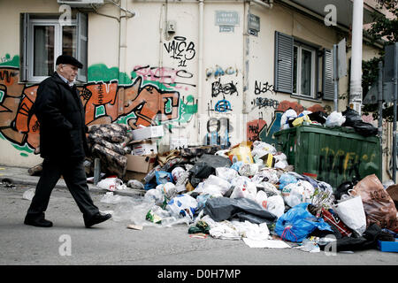 Thessalonique, Grèce. 26 novembre 2012. Un homme âgé passe devant un tas d'ordures. Collecte des déchets aujourd'hui à Thessalonique commence de nouveau après dix jours de grève par les travailleurs de l'assainissement. La municipalité a dit qu'il faudrait deux à trois jours pour éliminer plus de 2000 tonnes de déchets qui s'est accumulée pendant la manifestation. Banque D'Images