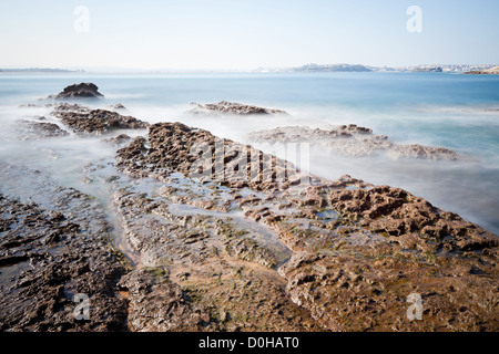 Los Tranquilos plage, côte rocheuse de la Cantabrie, dans le Nord de l'Espagne. La ville de Santander est à l'arrière-plan. Banque D'Images