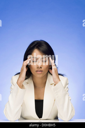 Frustrated businesswoman rubbing her temple Banque D'Images