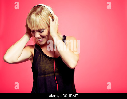 Attractive young woman tout en appréciant la musique de son mp3 player Banque D'Images