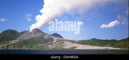 Volcan fumant dans Soufriere Hills sur l'île des Caraïbes de Montserrat après la catastrophe de l'éruption 1997 avec la route de la destruction par l'écoulement de lave dans la mer Banque D'Images