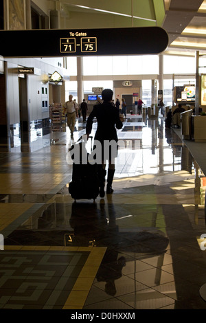 Les voyageurs aériens à pied à travers la borne airport corridor sur moyen de portes des aéroports, l'aéroport O'Hare, à Chicago, Illinois, États-Unis Banque D'Images