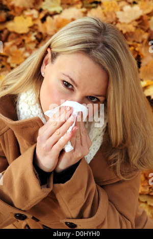 Jolie femme avec son nez de soufflage froid Banque D'Images