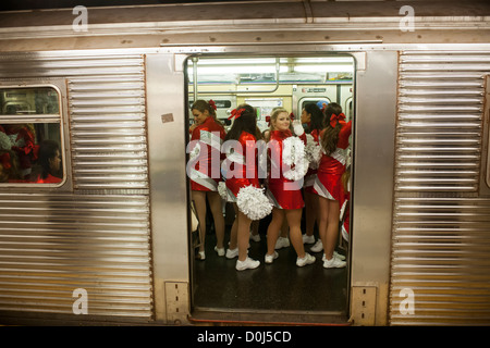 Les membres de l'équipe de cheerleading esprit universitaire, passer par le métro de New York Banque D'Images