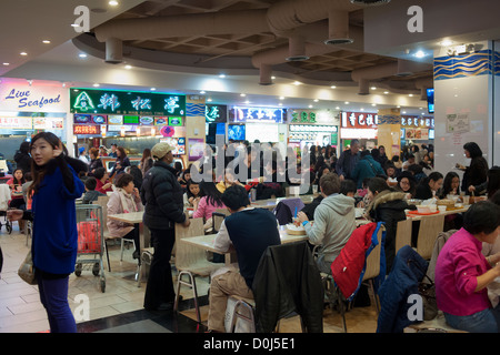 Diners dans le food court du Nouveau Monde Mall dans le quartier de Flushing Queens à New York Banque D'Images