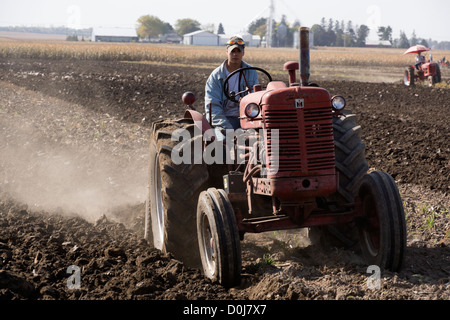 Meubles anciens tracteurs Farmall dans une démonstration de labour sur une ferme près d'Hébron, dans l'Illinois. Banque D'Images