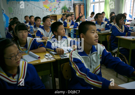 Des étudiants chinois, assister à une leçon dans une salle de classe à une école secondaire pour les enfants des travailleurs migrants à la périphérie de Beijing, Chine. 2012 Banque D'Images