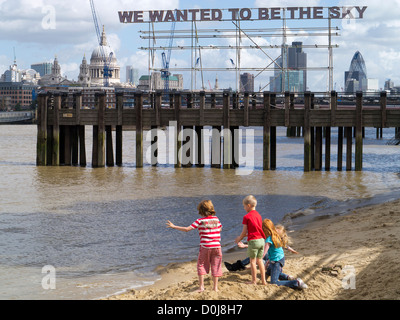 Enfants jouant à marée basse au cours de la Thames Festival à Londres. Banque D'Images