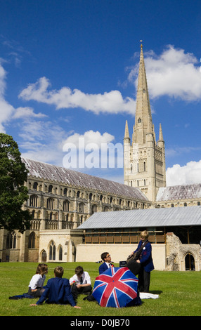 Les élèves de l'École de Norwich vous détendre sur l'herbe en face de la cathédrale. Banque D'Images