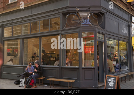 Les personnes bénéficiant d'un verre dans un café à Tottenham Court Road. Banque D'Images