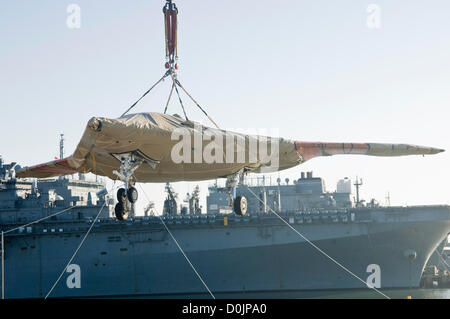 Un X-47B Unmanned Combat aéronef est transférée à l'envol du porte-avions USS Harry S. Truman le 26 novembre 2012 à Norfolk, VA. Le X-47B est la dernière technologie et l'UAV dans Truman est le premier porte-avions pour accueillir les opérations de vérification pour un avion sans pilote. Banque D'Images