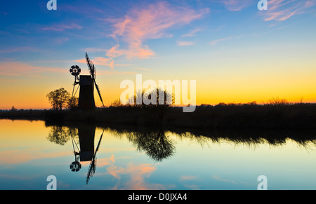 Turf Fen pompe éolienne se reflétant dans la rivière Ant au coucher du soleil. Banque D'Images