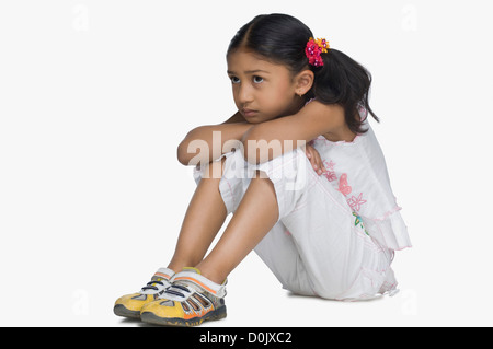 Girl resting son visage sur ses genoux Banque D'Images