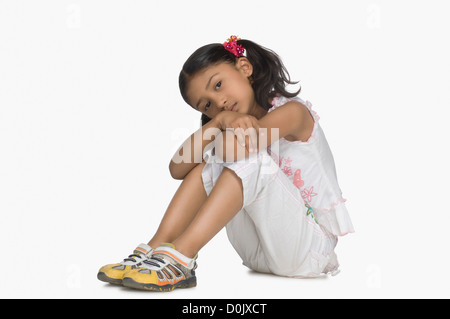 Portrait d'une jeune fille posant son visage sur ses genoux Banque D'Images