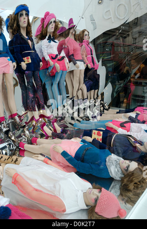 Une boutique de mode d'affichage fenêtre composée de mannequins reflétée dans un miroir. Banque D'Images