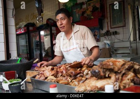 L'homme avec du porc de Carnitas tacos au Mercado à Coyoacan à Coyoacan, Mexico DF Banque D'Images