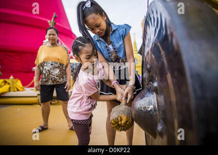 Le 27 novembre 2012 - Bangkok, Thaïlande - Soeurs battre un gong de prière au temple Wat Saket juste à Bangkok. Wat Saket, populairement connu comme le Mont d'Or ou ''Phu Khao Thong,'' est l'un des plus populaires et des plus anciens temples Bouddhistes de Bangkok. Il date de la période d'Ayutthaya (environ 1350-1767 AD) et a été considérablement rénové quand le Siamois d'Ayutthaya ont fui et ont établi leur nouveau capitol à Bangkok. Le temple est titulaire d'une foire annuelle en novembre, la semaine de la pleine lune. C'est l'un des plus populaires des foires du temple à Bangkok. ZUMA Press, Inc. / Alamy Live News Banque D'Images