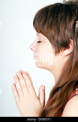 Ger fille croisa les mains dans la prière. Vue de profil Banque D'Images