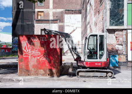 Mini pelle garé sur un site de construction en centre-ville de Montréal, province de Québec, Canada. Banque D'Images