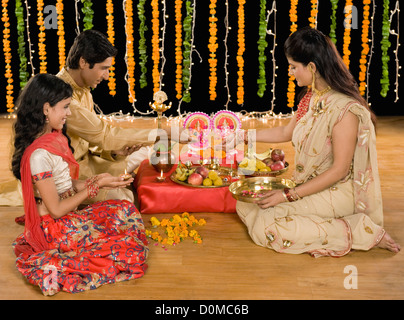 Les parents avec leur fille faisant Diwali pooja Banque D'Images