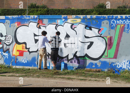 Les garçons graffitis sur le mur à l'aide d'aérosols. Front de mer de Brighton. East Sussex. L'Angleterre. 14/8 Banque D'Images