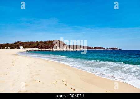 Océan bleu azur et sable parfait de plage peu fréquentée à Bahia de Chahue Huatulco Mexique Banque D'Images