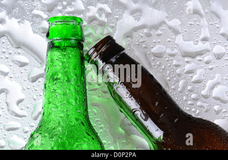 Libre de deux bouteilles de bière sur une surface en acier inoxydable. Une bouteille est vert l'autre brun. Banque D'Images