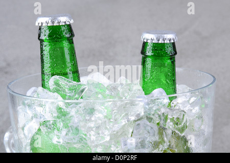 Libre de deux bouteilles de bière verte dans un seau à glace en cristal. Format horizontal sur un fond marbré gris. Banque D'Images