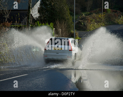 Voiture roulant dans de l'eau stagnante sur la route inondée, Cumbria, Angleterre, Royaume-Uni Banque D'Images