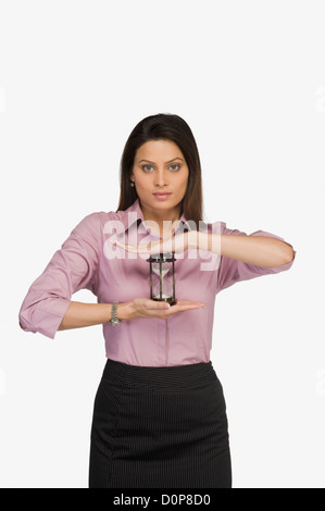 Businesswoman holding un sablier Banque D'Images