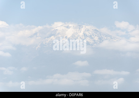 MONT KILIMANDJARO, Tanzanie — le sommet (sommet de Kibo) du Mont Kilimandjaro vu de la distance ci-dessous, avec sa neige et partiellement couvert de nuages. Banque D'Images