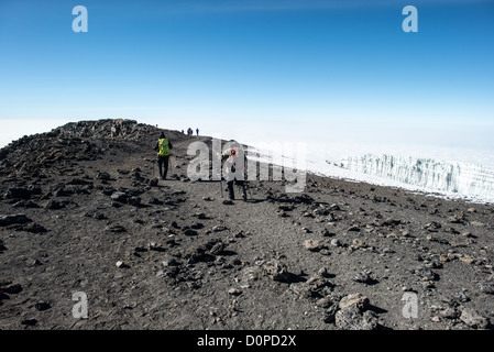 MONT KILIMANDJARO, Tanzanie — les alpinistes commencent la descente le long d'une crête à partir du pic Uhuru, le sommet du Mont Kilimandjaro. Un glacier est à droite du cadre. Banque D'Images