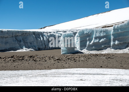 MONT KILIMANDJARO, Tanzanie — de épais champs de glace recouvrent un glacier sur le plateau près de Crater Camp à 18 810 pieds d'altitude, situé juste en dessous du sommet Kibo sur le Mont Kilimandjaro. Le camp sert de point d'étape en haute altitude pour les grimpeurs tentant d'atteindre le pic Uhuru, le point culminant de la montagne à 19 341 pieds. Le Kilimandjaro, la plus haute montagne d'Afrique, présente trois cônes volcaniques, dont Kibo, qui contient le cratère sommital. Les champs de glace glaciaires représentent une partie de la calotte glaciaire en diminution de la montagne, qui a considérablement reculé au cours des dernières décennies. Crater Camp est parmi les th Banque D'Images