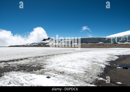 MONT KILIMANDJARO, Tanzanie — de épais champs de glace recouvrent un glacier sur le plateau près de Crater Camp à 18 810 pieds d'altitude, situé juste en dessous du sommet Kibo sur le Mont Kilimandjaro. Le camp sert de point d'étape en haute altitude pour les grimpeurs tentant d'atteindre le pic Uhuru, le point culminant de la montagne à 19 341 pieds. Le Kilimandjaro, la plus haute montagne d'Afrique, présente trois cônes volcaniques, dont Kibo, qui contient le cratère sommital. Les champs de glace glaciaires représentent une partie de la calotte glaciaire en diminution de la montagne, qui a considérablement reculé au cours des dernières décennies. Crater Camp est parmi les th Banque D'Images