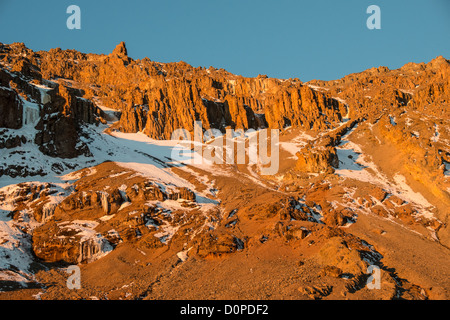 MONT KILIMANDJARO, Tanzanie — le soleil couchant jette une lumière dorée sur la brèche accidentée et escarpée de l'ouest, vue depuis le camp du glacier Arrow sur la route Lemosho du Mont Kilimandjaro. Banque D'Images