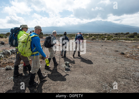 MONT KILIMANDJARO, Tanzanie — Un groupe d'alpinistes marchent vers le sommet du Mont Kilimandjaro, que l'on peut voir au loin à droite. Banque D'Images