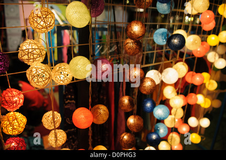 Lumières décoratives à vendre Vientiane Laos / VIENTIANE, Laos — des chaînes de lumières décoratives de couleurs vives sont exposées à la vente au marché nocturne sur le Quai Fa Ngum le long des rives du Mékong. Le marché fonctionne chaque soir le long de cette promenade populaire au bord de la rivière, où les vendeurs locaux vendent de l'artisanat, des textiles et des articles de décoration aux résidents et aux visiteurs. L'avenue tire son nom de Fa Ngum, le fondateur du XIVe siècle de LAN Xang, le premier Royaume lao unifié. Banque D'Images