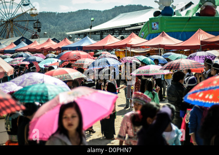 PHONSAVAN, Laos - Les jeunes hommes et femmes Hmong affluent à la Nouvelle Année festival à à Phonsavan au nord-est du Laos. Robe filles Hmong en costumes colorés et engager ball jeux de catch dans le cadre d'un rituel traditionnellement conçu pour trouver un mari. Les habitants de la région sont majoritairement d'ethnie Hmong. Banque D'Images