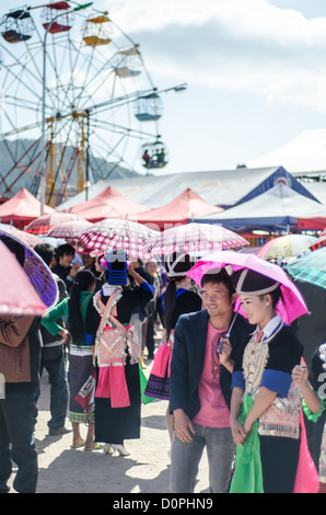 PHONSAVAN, Laos - Les jeunes hommes et femmes Hmong affluent à la Nouvelle Année festival à à Phonsavan au nord-est du Laos. Robe filles Hmong en costumes colorés et engager ball jeux de catch dans le cadre d'un rituel traditionnellement conçu pour trouver un mari. Les habitants de la région sont majoritairement d'ethnie Hmong. Banque D'Images