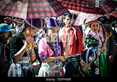 PHONSAVAN, Laos - Les jeunes hommes et femmes Hmong affluent à la Nouvelle Année festival à à Phonsavan au nord-est du Laos. Robe filles Hmong en costumes colorés et engager ball jeux de catch dans le cadre d'un rituel traditionnellement conçu pour trouver un mari. Les habitants de la région sont majoritairement d'ethnie Hmong. Banque D'Images