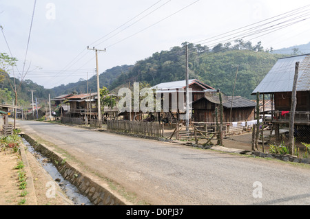 Village de tissage Plaine de jarres Province de Xiangkhouang Laos // PROVINCE DE XIENGKHOUANG, Laos — Un village spécialisé dans le tissage situé dans la Plaine de jarres dans le nord-est du Laos. La communauté dispose de cadres de maison en bois avec des toits en fer ondulé et des infrastructures électriques, ce qui indique une prospérité relative selon les normes rurales lao. Les métiers à tisser traditionnels sont positionnés sous les maisons surélevées, une pratique courante dans l'architecture du village lao qui maximise l'utilisation de l'espace. La plaine des Jarres est un paysage archéologique connu pour ses anciens sites de jarres en pierre dispersés sur le plateau. Xiangkhouang Banque D'Images