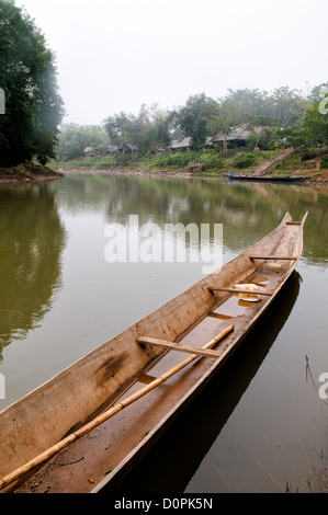 Bateau en bois rivière Nam Tha Luang Namtha Laos // LUANG NAMTHA, Laos — des bateaux en bois reposent sur les rives de la rivière Nam Tha à Luang Namtha, au nord du Laos. Ces bateaux traditionnels servent d'outils de transport et de pêche essentiels pour les communautés locales le long de la voie navigable. La rivière Nam Tha traverse la province de Luang Namtha, qui borde la Chine et du Myanmar dans le nord-ouest du Laos. La région est connue pour ses diverses communautés ethniques et son relief montagneux. La ville de Luang Namtha sert de capitale provinciale et de porte d'entrée à la zone protégée nationale de Nam Ha. Les rivières de la région restent au centre de l local Banque D'Images