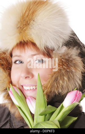 Redhead in hood chaud derrière les tulipes Banque D'Images